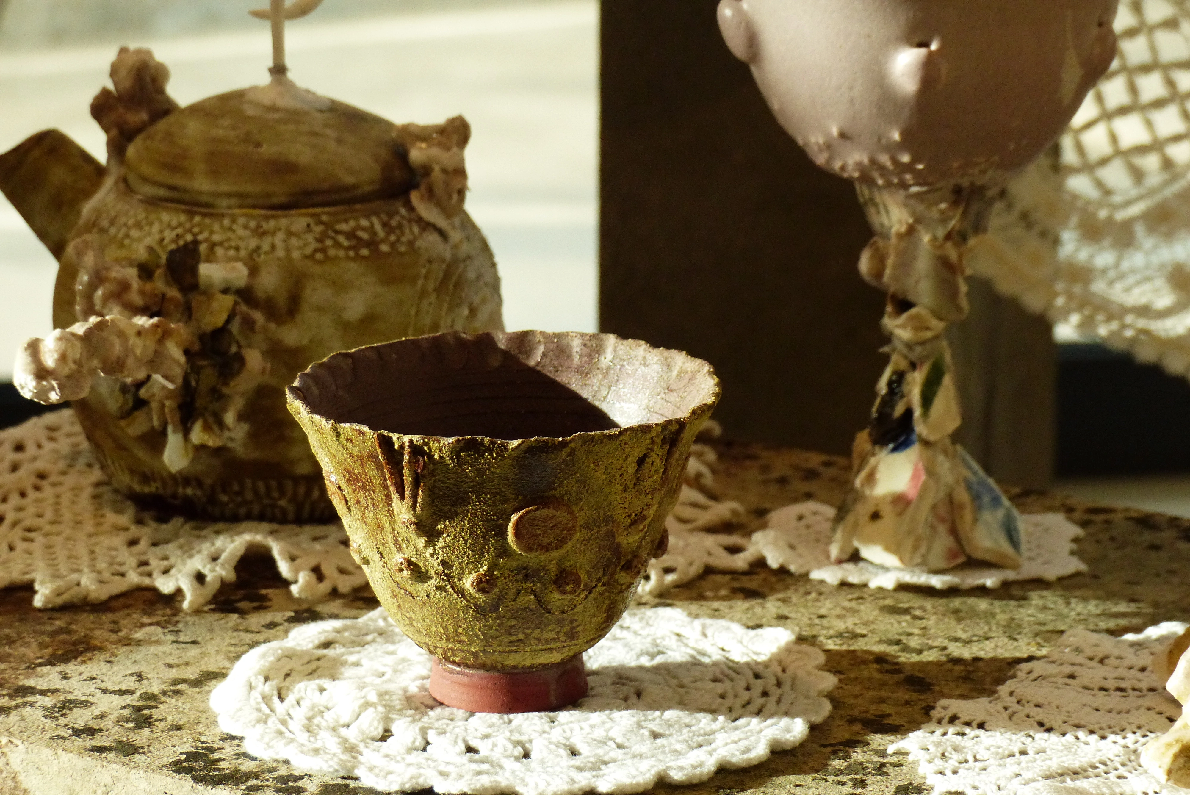 Sculpture d'une tasse tournée ornementé prise en photo dans une exposition de céramique